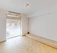 A bright room in a family house with a large window and a light floor.