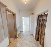 A hallway with a wall hanger and a decorative curtain in a family house.