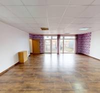 A spacious room in a family house with a wooden decor floor and wallpaper.