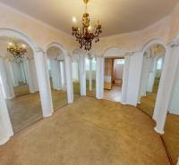 Interior of a family house with arched mirrors, chandelier, and carpet.