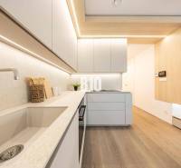 A kitchen in a 3-room apartment with a wooden decor floor and minimalist design.