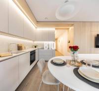 Stylish kitchen in a 3-room apartment with wood-patterned flooring and modern furniture.