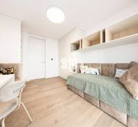 A minimalist room with a sofa, light furniture, and a wooden decor floor in a three-room apartment.