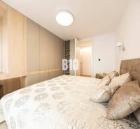 Bedroom in a 3-room apartment with storage spaces and a bed with patterned textiles.