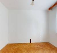 A room in a 3-room apartment with a wooden decor floor and white walls.