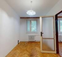 A room in a 3-room apartment with a wooden decor floor and white walls.