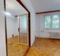 A room with a wooden decor floor and a large window in a 3-room apartment.