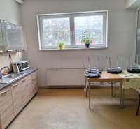 A kitchenette in warehouses and halls with wooden decor, chairs on the table, houseplants.