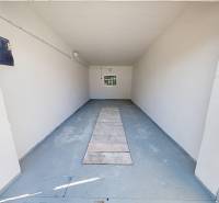 An empty garage with a blue floor and white walls.