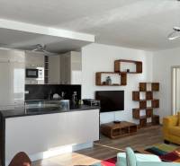 Living room in a 3-room apartment with a kitchenette, yellow sofa, and wooden decor.