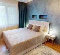 Bedroom of a family house with a decorative wall, bed, and floor with a wooden decor.