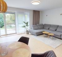 Living room in a family house with a large window, a sofa, and a floor with a wooden decor.