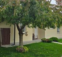 A family house on Lotosová Street in Malinovo with a front garden and a tree in front of the entrance.