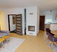 Living room with a fireplace, sofa, and dining table in a family house.