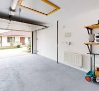 A garage in a family house on Lotosova Street in Malinovo, car, shelf, scooter, open gate.