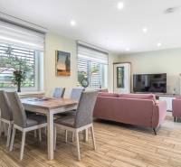 Living room in a family house with a sofa, television, and dining table.