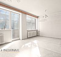 An empty room with large windows and radiators in a family house.
