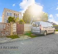 A family house in Veľká Mača with a car on the driveway and sunny weather.