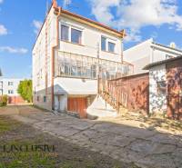 A family house in Veľká Mača with a glazed veranda and an adjacent building in the yard.