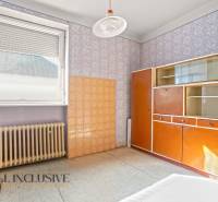 Vintage wardrobe with decorative wallpaper and radiator in the interior of a family house.