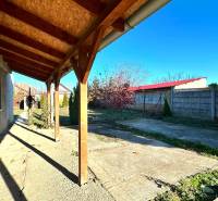 A family house in Horné Saliby with a terrace and a garden surrounded by a fence.