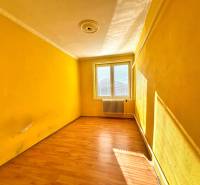 A room with a wooden floor and yellow walls in a family house.
