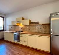 A kitchen in a family house with a wooden decor floor and a stainless steel refrigerator.
