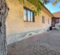 A family house on Prostredná Street in Svätý Jur with a paved yard and a tree.