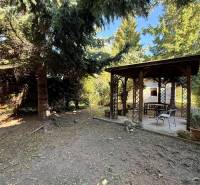 The garden of a family house on Prostredná Street in Svätý Jur with a gazebo among the trees.