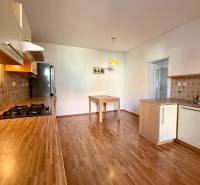 A kitchen in a family house with a wooden decor floor and a wooden kitchen unit.