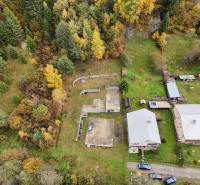 An aerial view of residential plots in Bacúch among trees and buildings.