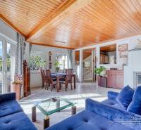 Living room in a family house with a fireplace, blue sofa, and dining table.