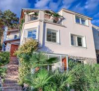 A family house on a street in Bratislava - Devín with an access garden path and plants.