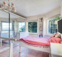 Bright room in a family house with a bed, mirror, and wooden floor decor.