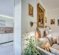 Interior of a family house with a white kitchen unit and a cozy corner with a sofa and decorations.