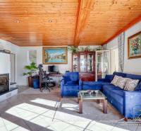 Living room in a family house with a fireplace, blue sofa, and wooden decor flooring.