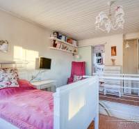 Bright cabin room with a bed, floral pillow, and decorative lighting.