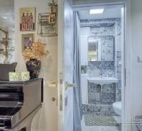 Interior of a cottage with a piano, decorations, and a bathroom with mosaic tiles.
