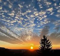 Sunset over the forest and hills in Bratislava - Devín, with clouds in the sky.