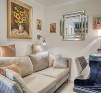 Living room with a sofa, piano, and paintings in a family house.