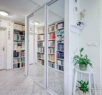 A cottage with a mirrored wardrobe, books, and plants creates a cozy space.