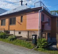 A family house in Lalinok in Divinka, with a colorful facade and a metal fence.