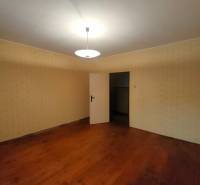 A room in a family house with a wooden decor floor and light-colored walls.