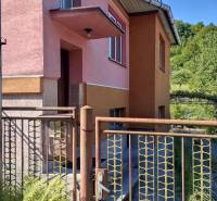 A family house in Divinka on Lalinok Street with a pink facade and a metal gate.