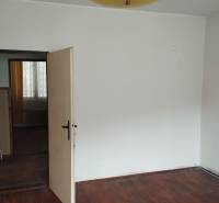 A room in a family house with a wooden decor floor and a yellow light fixture.