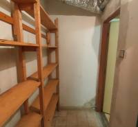 Storage space in a family house with wooden shelves and a light floor.