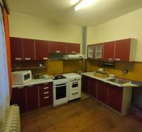A kitchen in a family house with appliances and a wooden decor floor.
