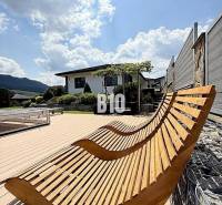 Wooden loungers on the terrace by the villa in Súľov-Hradná, overlooking the garden.