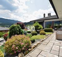 A garden by the villa in Súľov-Hradná with manicured plants and a view of the mountains.