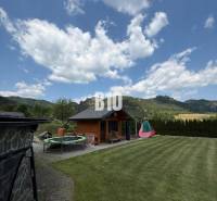A garden with a cottage and a trampoline in a villa in Súľov-Hradná.